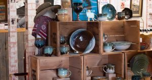 Handmade pottery displayed on wooden crates inside Bliss Marketplace in downtown Willimantic.